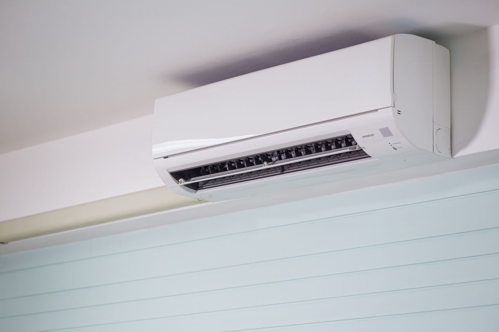 Wall-mounted air-conditioning unit with open vents in a light interior